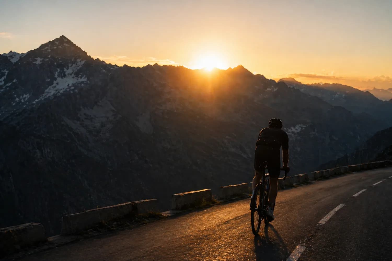 Cycliste en ascension de col au lever du jour — silhouette en contre-jour